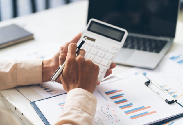 Close up hand of stress young asian businessman,male is pressing a calculator to calculate tax income and expenses, bills, credit card for payment or payday at home, office.Financial, finance concept.